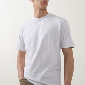 Model wearing Boss Black Casual H Taut Logo T-Shirt in Open White, crew neck, short sleeves, styled with khaki trousers