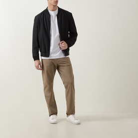 Model wearing Boss Black Casual H Taut Logo T-Shirt in Open White, styled with black bomber jacket, tan trousers and white trainers.