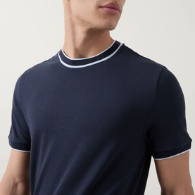 Model wearing Boss Black Casual Thompson Tipped T-Shirt in dark blue with white tipped crew neckline and short sleeves