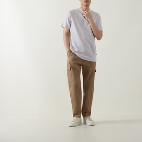 Model wearing Boss Black Casual Thompson Textured Logo T-Shirt in Open White, styled with tan cargo trousers and white trainers.