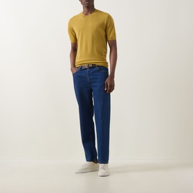 Model wearing Boss Black Casual gold virgin wool crew neck knit tee, styled with blue trousers, brown belt and white trainers.