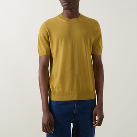 Model wearing Boss Black Casual gold crew neck knit tee in 100% virgin wool, styled with dark blue jeans