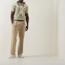 Model wearing Boss Black Casual Umauro Knitted Sweater in Dark Beige, crew neck, short sleeves, styled with tan trousers and white trainers.
