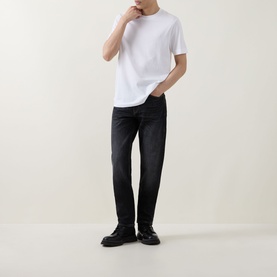 Model wearing Boss Black Casual white crew neck T-shirt in cotton, styled with dark washed jeans and black shoes
