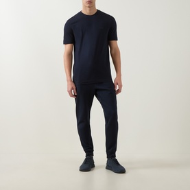 Model wearing Boss Black Casual Thompson Logo T-Shirt in dark blue with matching joggers and grey trainers