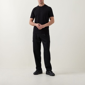 Model wearing Boss Black Casual black crew neck cotton T-shirt, styled with black trousers and black chunky trainers.