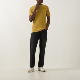 Model wearing Boss Black Casual gold crew neck T-shirt in 100% cotton, styled with dark trousers and white trainers.