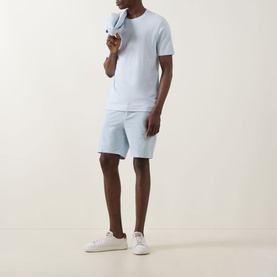 Model wearing Boss Black Casual Open Blue cotton crew neck T-shirt, styled with matching light blue shorts and white trainers.
