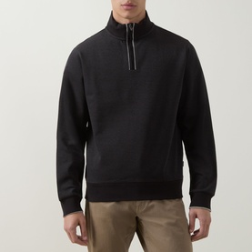 Model wearing Boss Black Casual black cotton half-zip sweatshirt with ribbed cuffs and hem, styled with khaki trousers