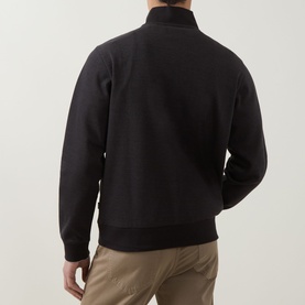 Model wearing Boss Black Casual black cotton half-zip sweatshirt, rear view, styled with beige chinos.