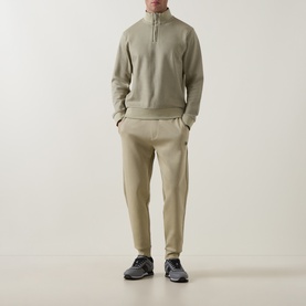 Model wearing Boss Black Casual Sidney Half-Zip Sweatshirt in dark beige with matching tapered trousers and grey trainers.