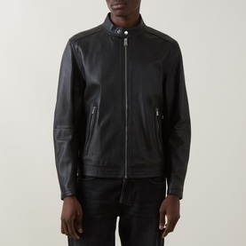 Model wearing Boss Black Casual black lambskin leather jacket with stand collar, zip fastening and zip pockets, styled with dark trousers.