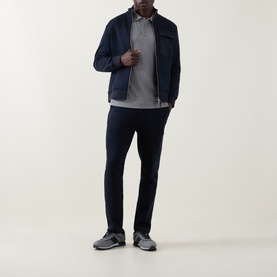 Model wearing Boss Black Casual Parlay Logo Polo Shirt in Open Grey, styled with navy zip jacket, navy trousers and grey trainers.
