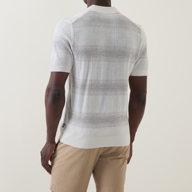 Model wearing Boss Black Casual C-Lamoroso Striped Knitted Polo Shirt in Open White, back view, styled with beige chinos.