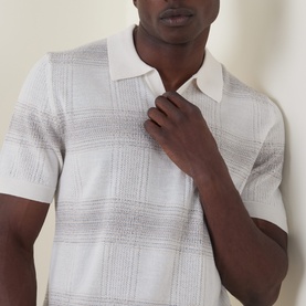 Model wearing Boss Black Casual C-Lamoroso Striped Knitted Polo Shirt in Open White, open placket, short sleeves, subtle grid-stripe texture