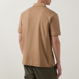 Model wearing a camel short-sleeve polo shirt, back view, styled with olive cargo trousers