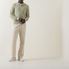 Model wearing Boss Black Casual H Lomarino Logo Polo Sweater in dark beige with cream tailored trousers and white trainers