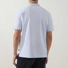 Model wearing Boss Black Casual H Pei Logo Zip Polo Shirt in Open Blue, rear view, short sleeves, styled with dark trousers