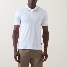 Model wearing Boss Black Casual H-Phillipson Logo Polo Shirt in white with tipped collar trims, styled with khaki trousers.