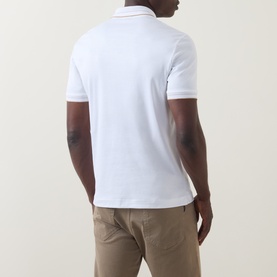 Model wearing Boss Black Casual H-Phillipson Logo Polo Shirt in white, back view, with tipped trims, styled with beige chinos.