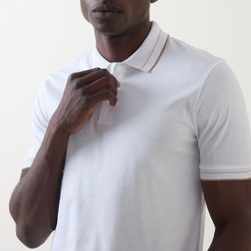 Model wearing Boss Black Casual H-Phillipson Logo Polo Shirt in white with tipped collar trims and button fastenings, close-up view