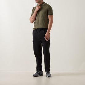 Model wearing Boss Black Casual Open Green cotton polo shirt, styled with black cargo trousers and grey trainers.