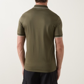Model wearing Boss Black Casual Open Green cotton polo shirt, rear view, with tipped collar and cuffs, styled with black trousers.