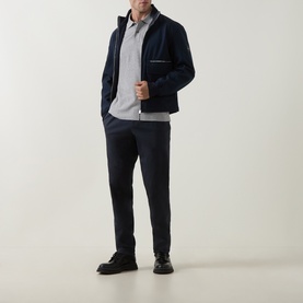 Model wearing Boss Black Casual Open Grey cotton polo, styled with navy zip-up jacket, matching navy trousers and black leather shoes.