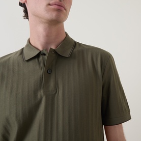 Model wearing Boss Black Casual Parlay Polo Shirt in Open Green with textured stripe finish, contrast tipping, polo collar and two-button placket