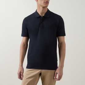 Model wearing Boss Black Casual Parlay Logo Polo Shirt in dark blue, two-button placket, short sleeves, styled with beige chinos