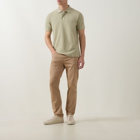 Model wearing Boss Black Casual dark beige cotton polo shirt with khaki chinos and white trainers