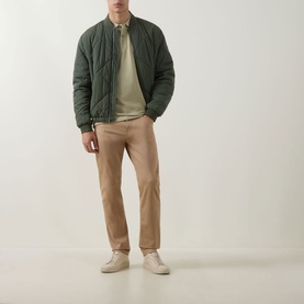 Model wearing Boss Black Casual Dark Beige cotton polo, styled with olive quilted bomber jacket, beige chinos, and cream trainers.