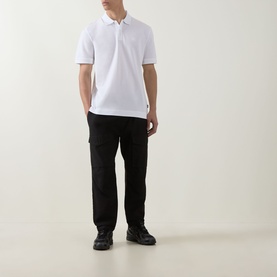 Model wearing Boss Black Casual Parris Logo Polo Shirt in white with black cargo trousers and black chunky boots.