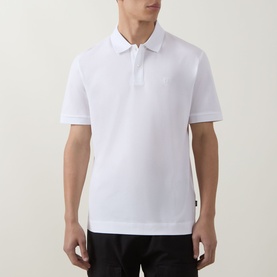 Model wearing Boss Black Casual Parris Logo Polo Shirt in white, short sleeves, two-button placket, subtle chest logo, paired with black trousers