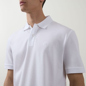 Model wearing Boss Black Casual Parris Logo Polo Shirt in white, showing embroidered chest logo, polo collar and two-button placket