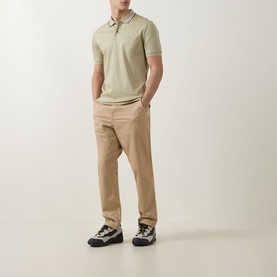 Model wearing Boss Black Casual dark beige cotton polo with tipped collar, styled with beige chinos and chunky trainers