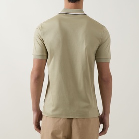 Model wearing Boss Black Casual dark beige cotton polo shirt, rear view showing tipped collar and short sleeves, styled with beige trousers