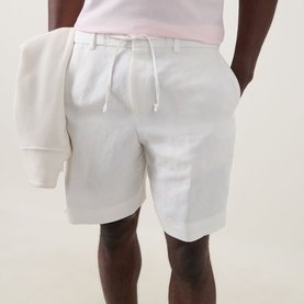 Model wearing Boss Black Casual Peter C Drawstring Shorts in Open White linen blend, with white drawstring waist, styled with a pale pink top.
