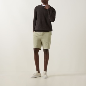 Model wearing Boss Black Casual Kane Chino Shorts in Dark Beige, slim-leg fit, styled with dark brown knit and white trainers.