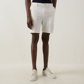 Model wearing Boss Black Casual open white cotton shorts, styled with white low-top trainers