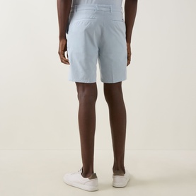 Model wearing Boss Black Casual Open Blue cotton-elastane shorts, back view, styled with white trainers