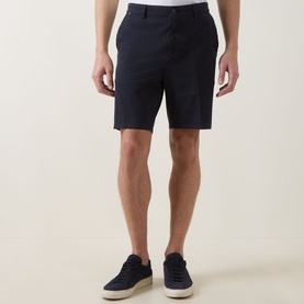 Model wearing Boss Black Casual dark blue cotton shorts, styled with navy suede trainers on white soles.
