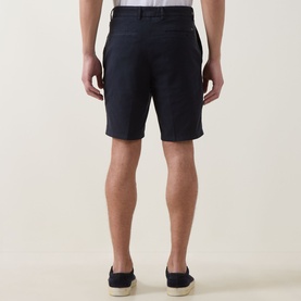 Model wearing Boss Black Casual dark blue cotton shorts, shown from behind, styled with navy slip-on shoes
