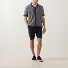 Model wearing Boss Black Casual dark blue cotton shorts, styled with a grey striped zip-up shirt and navy trainers.