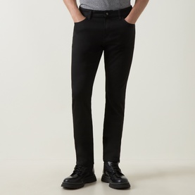 Model wearing Boss Black Casual H-Delaware Slim-Leg Jeans in black, styled with black leather chunky-sole shoes.