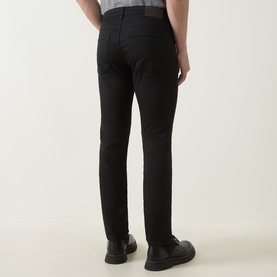 Model wearing Boss Black Casual H-Delaware Slim-Leg Jeans in black, shown from behind, styled with black leather shoes.