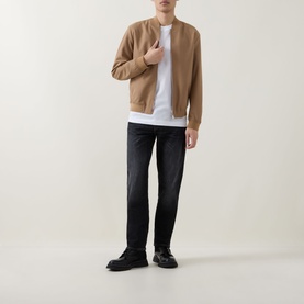 Model wearing Boss Black Casual charcoal straight jeans with a camel bomber jacket, white T-shirt and black chunky trainers.