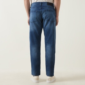 Model wearing Boss Black Casual P-Re.Maine Slim-Leg Jeans in dark blue mid-wash stretch denim, tapered leg, five-pocket styling, rear view