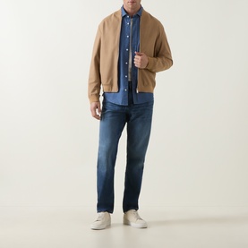 Model wearing Boss Black Casual P-Re.Maine Slim-Leg Jeans in dark blue, styled with a camel bomber jacket, blue shirt and white trainers.