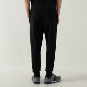 Model wearing Boss Black Casual black cotton-blend sweat bottoms, rear view, styled with grey trainers.